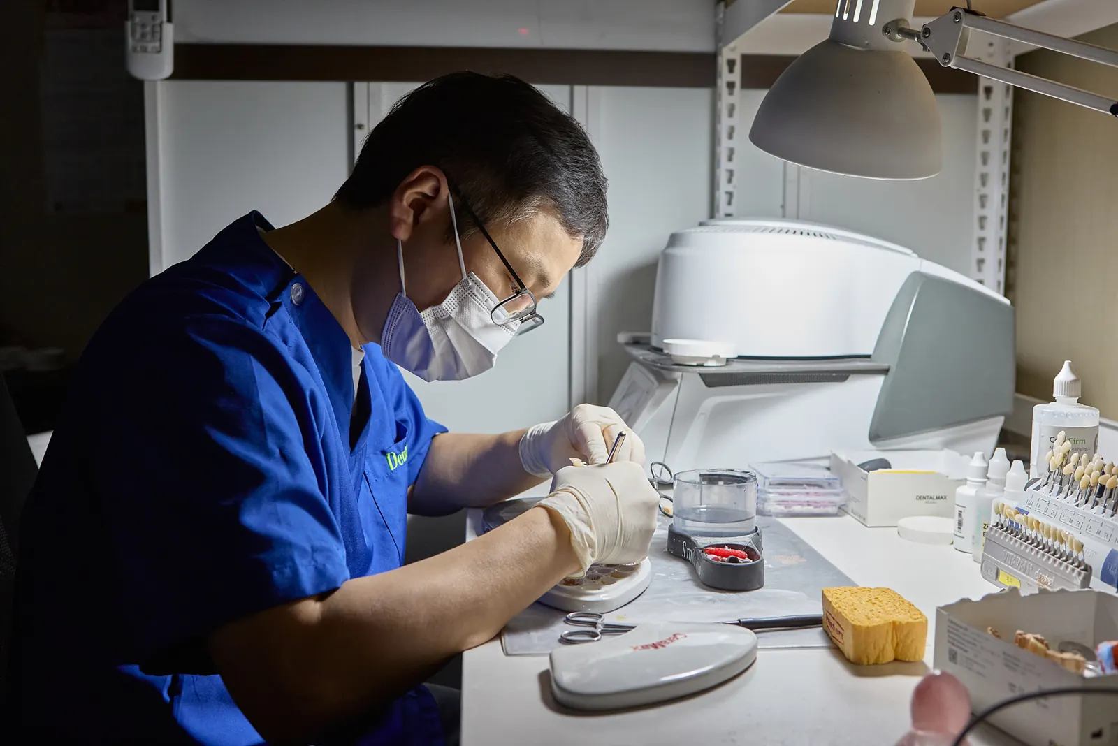 Dental technician hand-finishing a restoration in the in-house lab